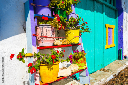 Colorful flower pots in front of fishing boat house in Klima village, Milos island, Cyclades, Greece © pkazmierczak