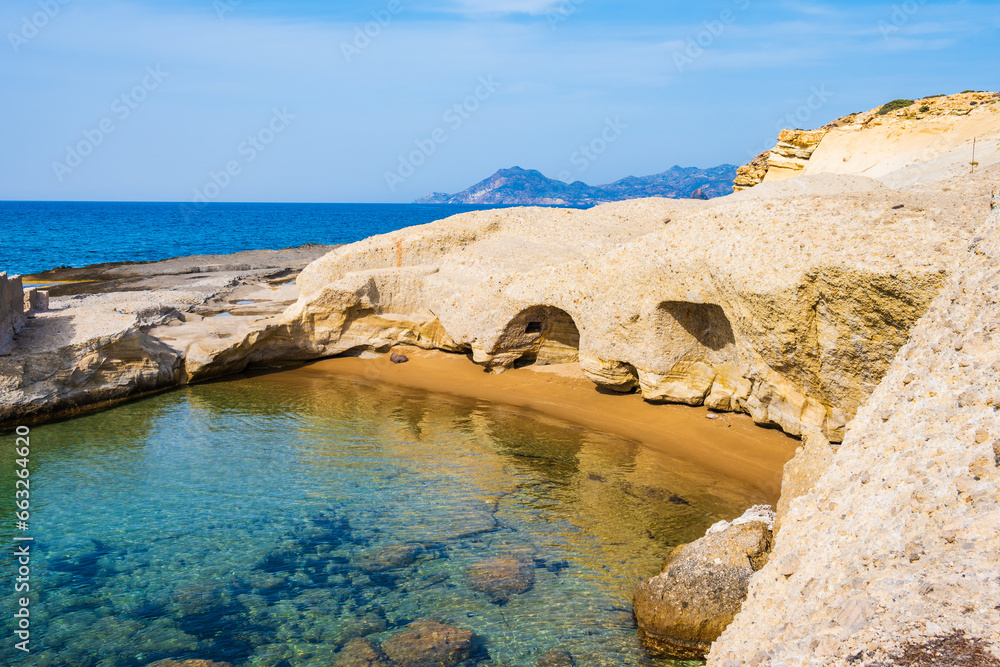 View of beautiful cave on sandy Pachena beach with azure sea water, Milos island, Cyclades, Greece