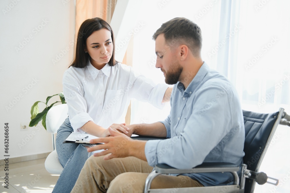 Young bearded man on wheelchair during home psychotherapy Young bearded man on wheelchair during home psychotherapy
