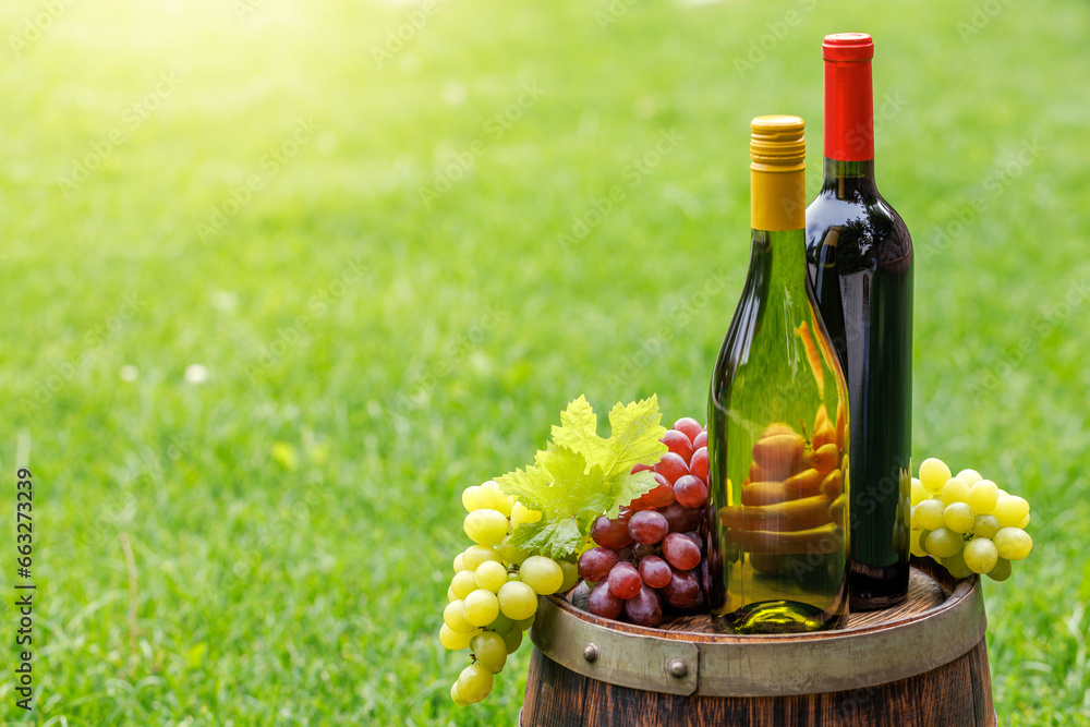 Fototapeta premium Wine bottles and grape on barrel