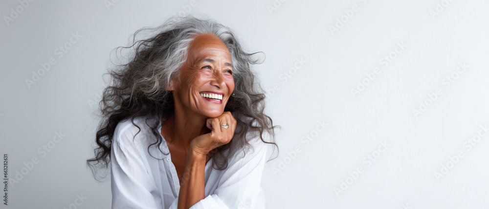 Portrait of a happy smiling beautiful aging mature woman with smooth healthy face skin and long gray hair on white background Portrait of a happy smiling beautiful aging mature woman with smooth healthy face skin and long gray hair on white background