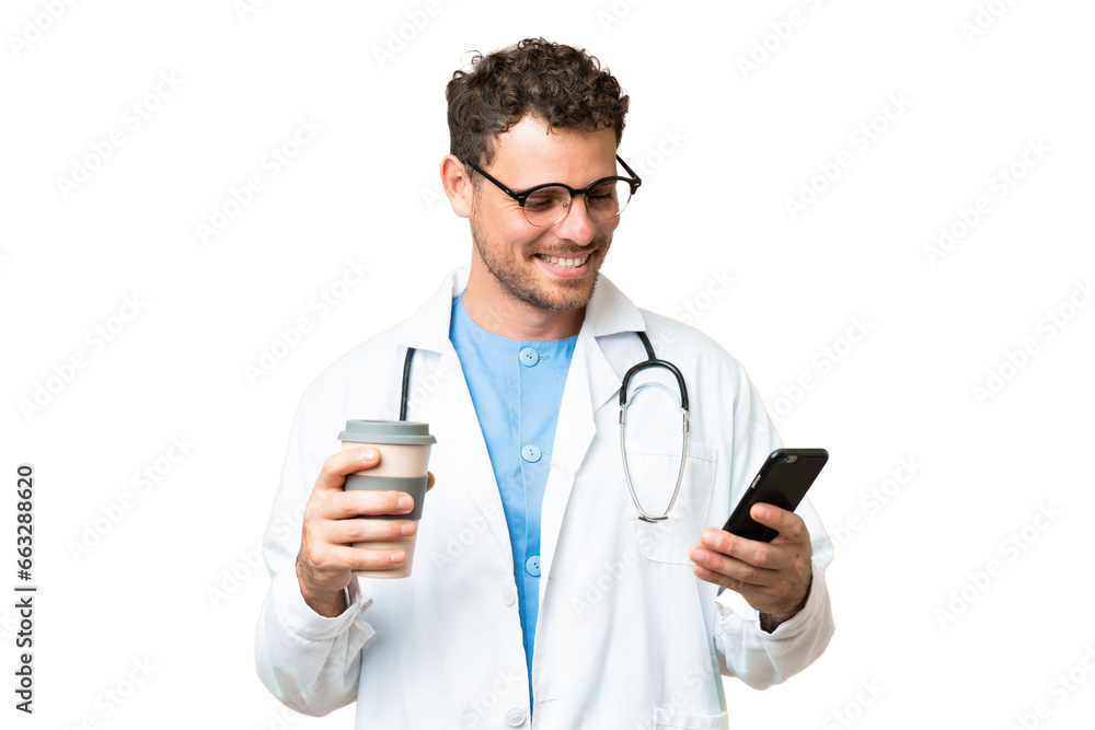 Brazilian doctor man over isolated chroma key background holding coffee to take away and a mobile Brazilian doctor man over isolated chroma key background holding coffee to take away and a mobile