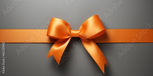 Orange gift ribbon with a bow against a gray background