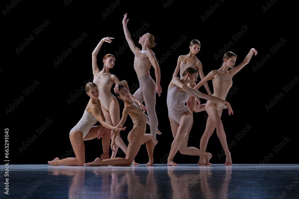 Obraz premium Talented, beautiful, artistic young people in motion, ballet dancers making creative performance against black background. Concept of classical and modern dance, beauty, creativity, art, theater