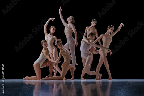 Talented, beautiful, artistic young people in motion, ballet dancers making creative performance against black background. Concept of classical and modern dance, beauty, creativity, art, theater