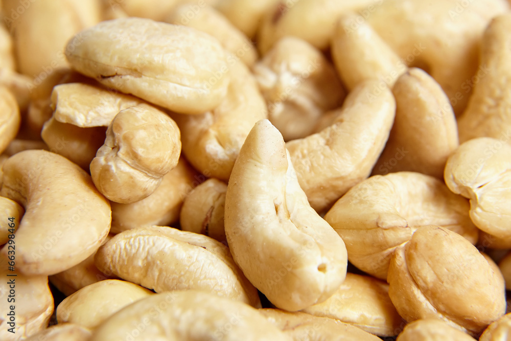 Fototapeta premium Cashew nut heap food texture background, macro shot. Yellow cashew kernels