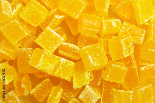 Diced mango dried fruits texture background, top view. Dehydrated mango chips dices, sweet food closeup. The sight of candied mango up close is a feast for the eyes