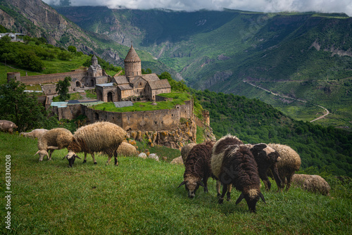 Aerial view of sheeps grazing near the Tatev Monastery on the rocks, a monastery complex with view over the valley and mountains, Tatev, Syunik Province, Armenia. photo