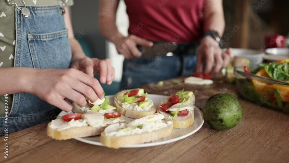 mother and her little girl decorating a healthy cheese sandwiches with vegetables for the breakfast on the kitchen table mother and her little girl decorating a healthy cheese sandwiches with vegetables for the breakfast on the kitchen table