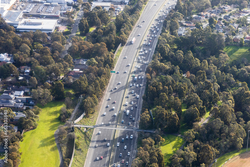 Aerial view of Motorway Amidst a Scenic Landscape of Parks and Homes, Victoria, Australia.