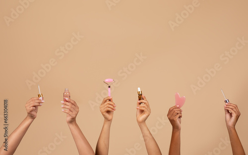 Diverse female hands hold beauty products, studio, copy space