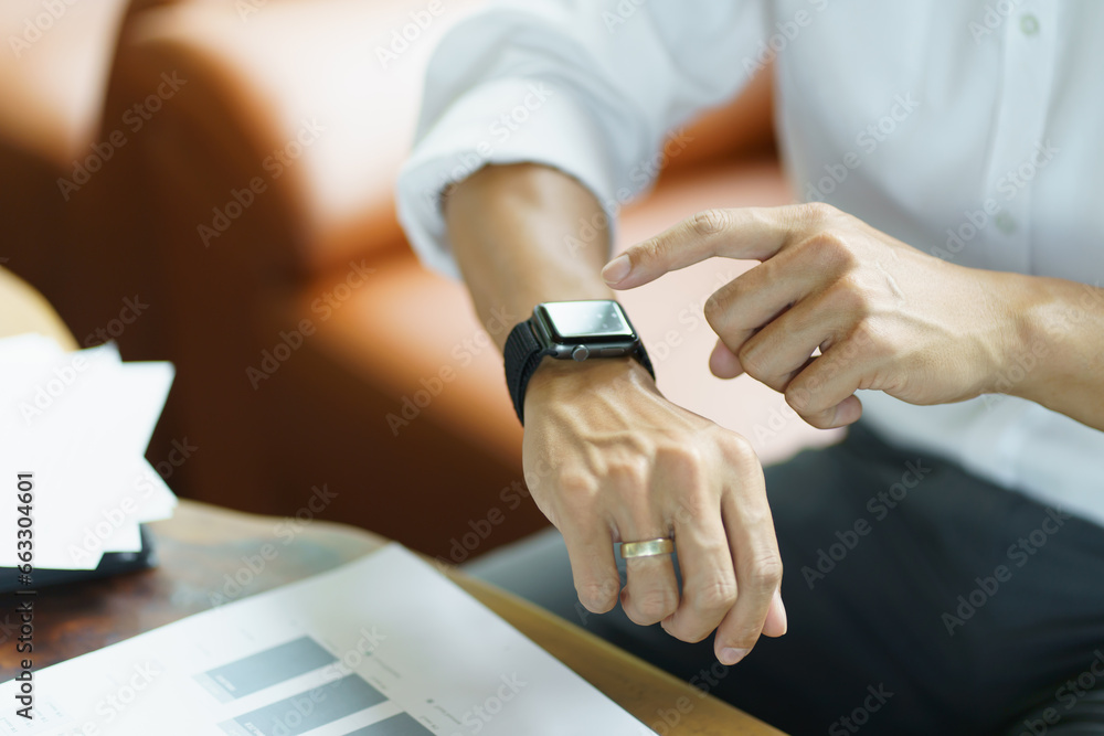 Obraz premium Business man Looking at&nbsp;smart watch In Office online connect Gadget technology