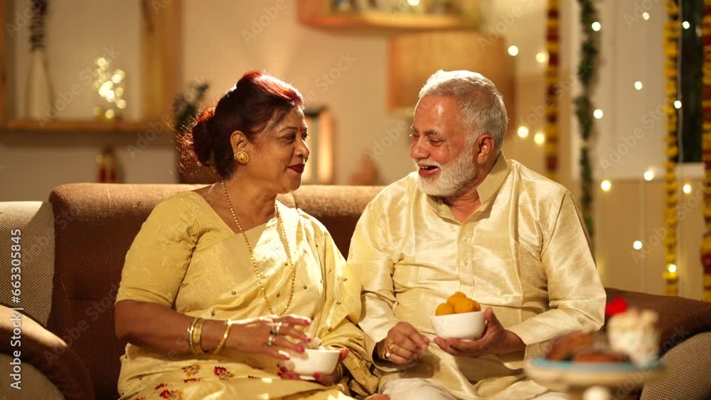 Indian aged Husband feeding sweets to her wife on the diwali festival