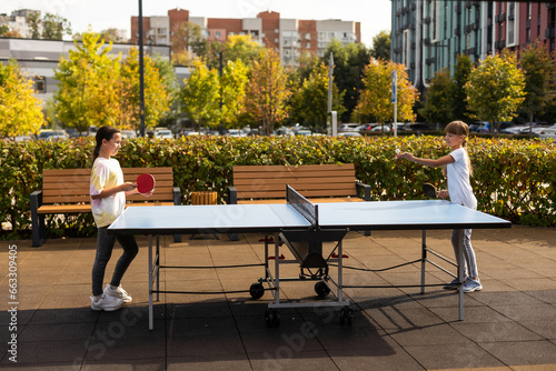 Little children playing ping pong in park photo