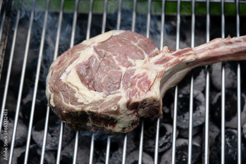 Frisches Tomahawk Steak mit Kräutern und Gewürzen photo