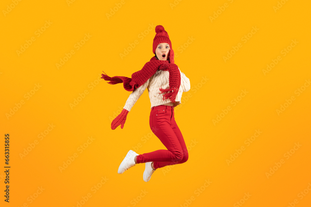 Excited Lady In Knitted Hat And Gloves Jumping, Yellow Background
