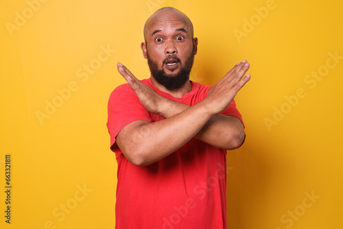 Bearded fat man showing STOP or rejection expression crossing arms doing negative sign