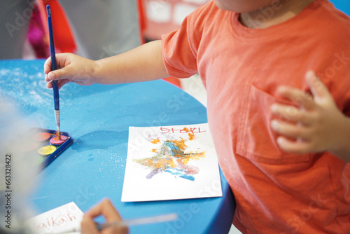 little toddler colouring with salt and paint technique. boy at school doing arts with salt.                