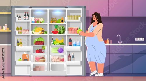 pregnant woman standing near refrigerator with fruits and vegetables nutrition diet during pregnancy motherhood expectation concept