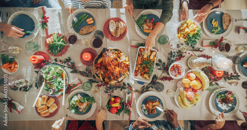 Obraz na plátně Diverse Group of Relatives and Friends Sitting Together Behind a Dining Table with Tasty Meals and Festive Decorations