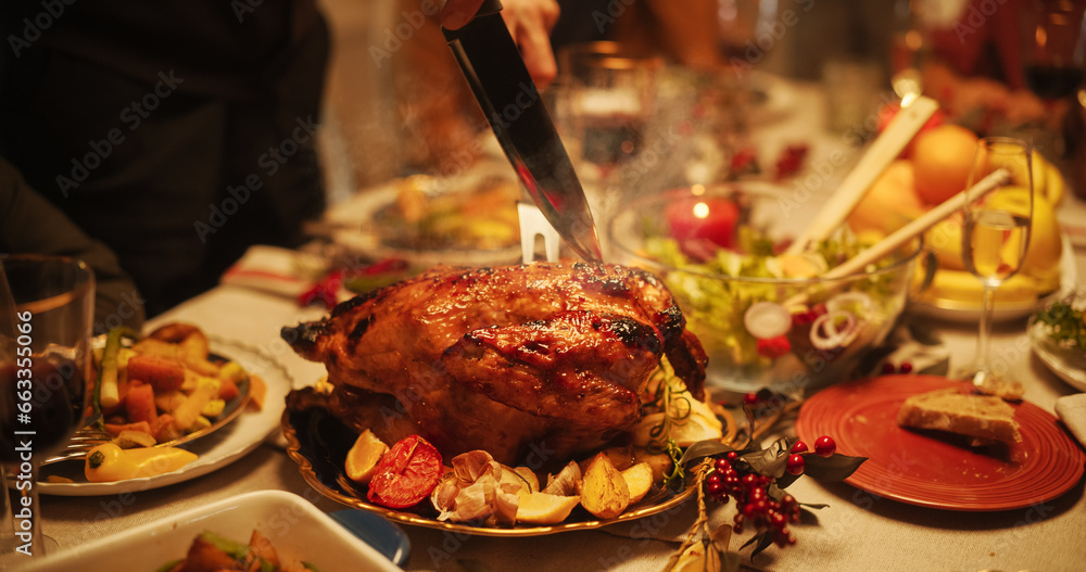 Zoom Out of a Delicious Main Course Meal on a Festive Christmas Table. Young Man is Carving a Turkey. Tasty Dishes and Stylish Decorations Prepared for a Family Dinner at Home - obrazy, fototapety, plakaty 