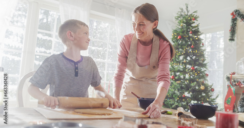 Portrait of Mother and Son Baking Together During Christmas. Cute Little Boy and his Mom Preparing Dough and Making Gingerbread Cookies. Happy Childhood Memories of Holidays