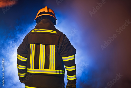 firefighter at the scene of an emergency at night from behind