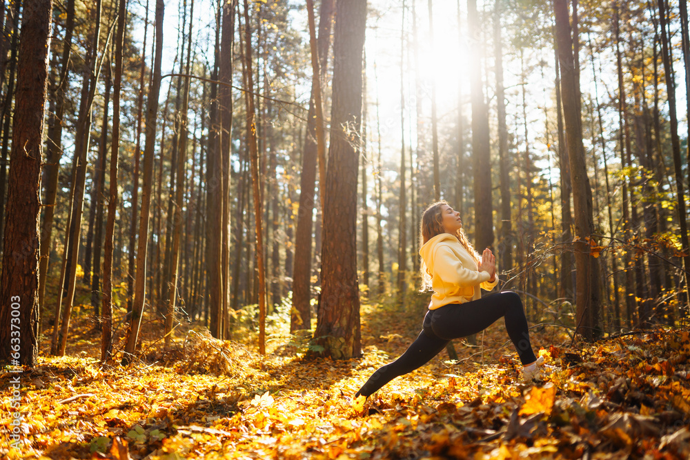 Active woman practices yoga in the autumn forest among yellow fallen leaves, catches zen. Concept of meditation, relaxation. Active lifestyle. Active woman practices yoga in the autumn forest among yellow fallen leaves, catches zen. Concept of meditation, relaxation. Active lifestyle.