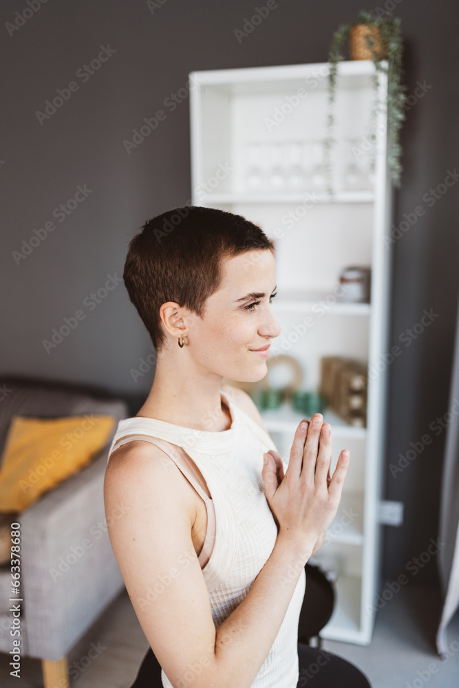 Young Modern Woman with Short Hair Practicing Yoga in Her Apartment Young Modern Woman with Short Hair Practicing Yoga in Her Apartment
