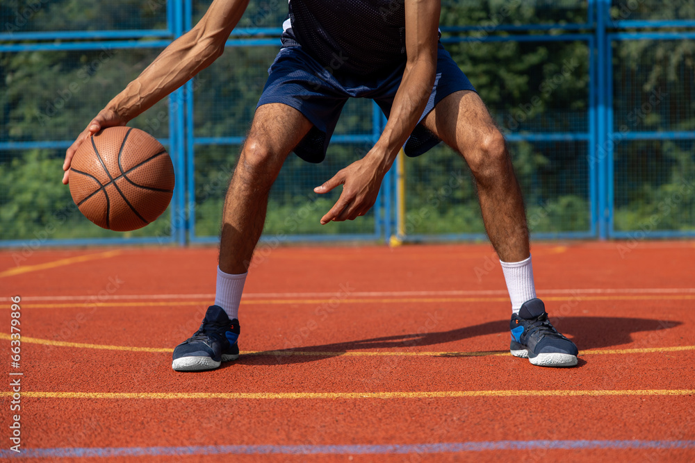 Unrecognizable man playing basketball at court. Unrecognizable man playing basketball at court.
