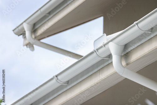 white plastic rain gutter and dark sky. concept : preparing maintenance rain gutter before rainy season.