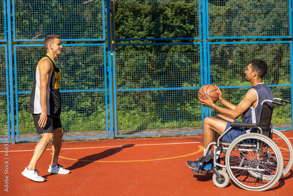 Man with disability in wheelchair and personal trainer for recovery motivation playing basketball.