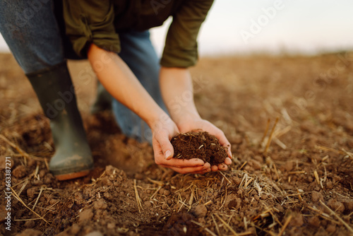 Close-up of a woman farmer's hands holding fresh soil. An experienced farmer checks the quality of the soil. Agriculture, gardening concept.