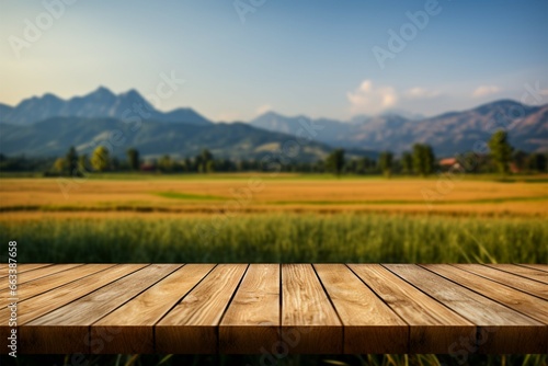 Scenic wooden table amidst a sunlit field with mountain backdrop