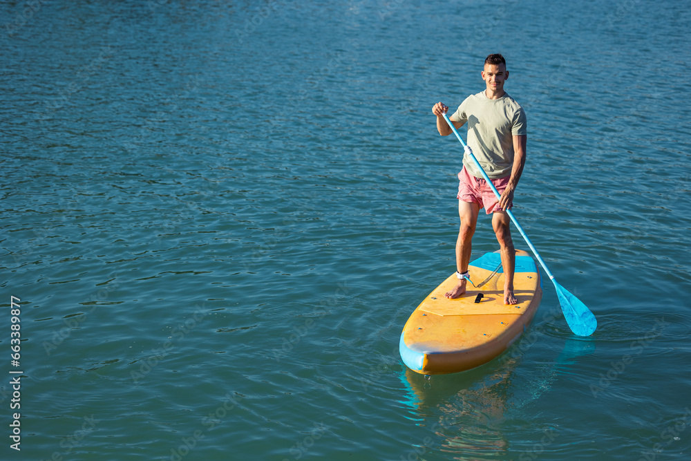 Man standing on the supboard in ocean.