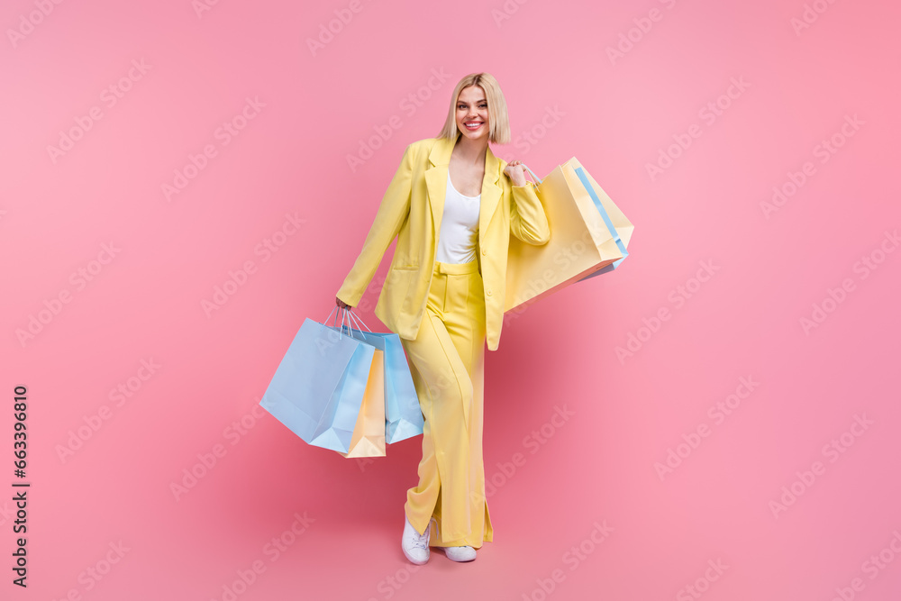 Full length portrait of positive stunning person hands hold mall shop bags isolated on pink color background