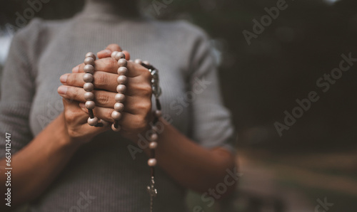 A young woman is holding a cross to pray for God's blessings.