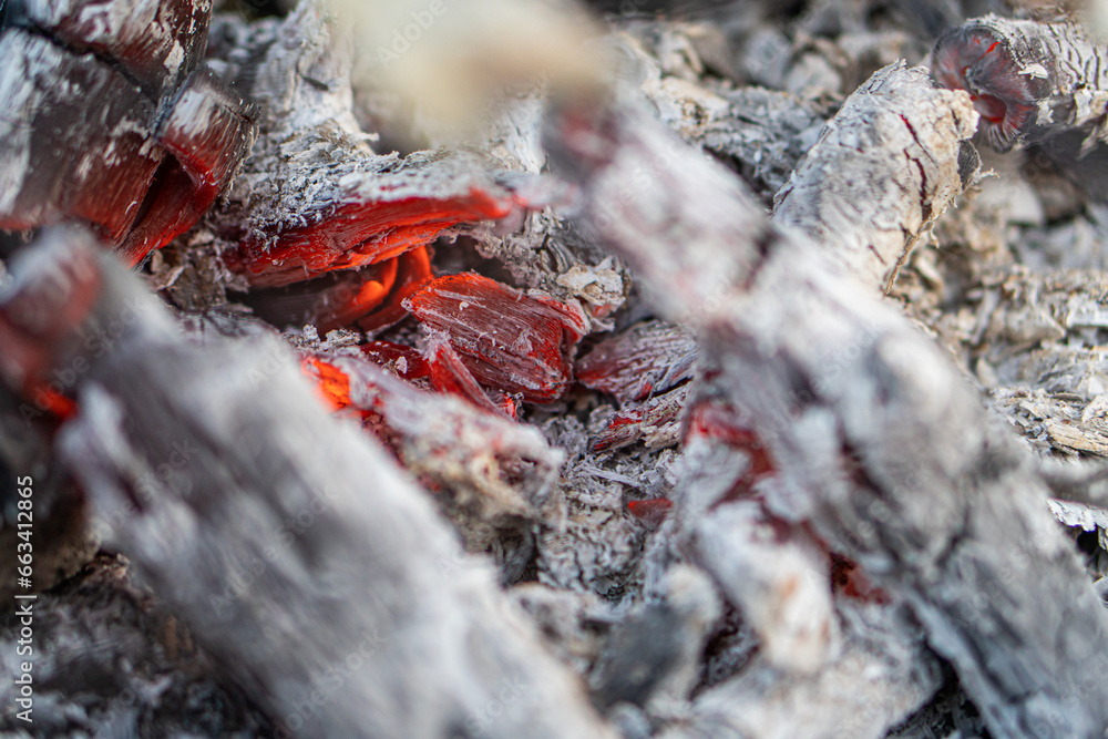 Dark black background of burnt wood with red hot embers still burning. Dark black background of burnt wood with red hot embers still burning.