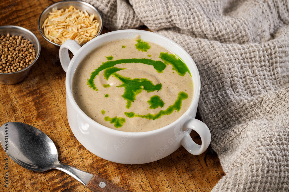 Creamy mushroom soup in a white plate on a wooden background Creamy mushroom soup in a white plate on a wooden background