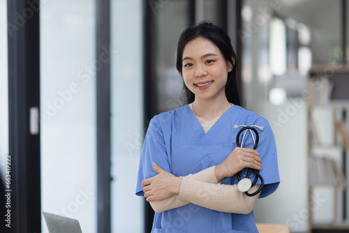 Free Download Healthcare and medical staff concept. Young Asian female doctor with a stethoscope standing in medical practice.  - GFXLoad