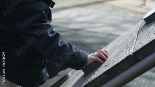 Child climbing playground structure, close-up of small boy's hand gripping, going up exercising in outdoor during fall season