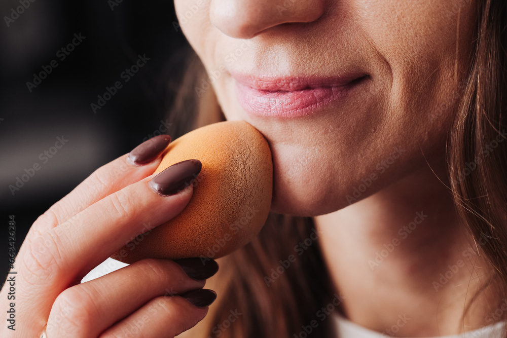 Beauty blender makeup sponge background. Young woman doing makeup. Girl applying foundation on her face using sponge. Happy woman smile. European face. Woman taking care of her skin. - obrazy, fototapety, plakaty 