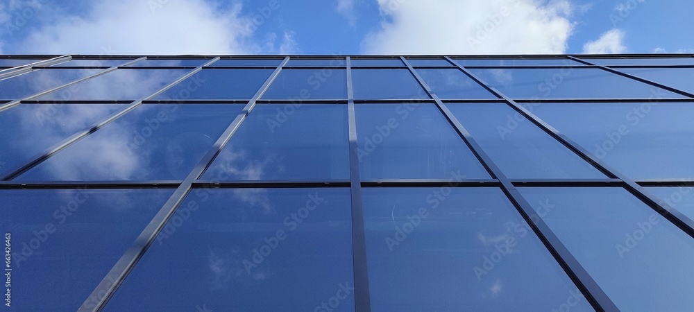 Modern glass building against the blue sky. Bottom view of modern skyscraper in business district Modern glass building against the blue sky. Bottom view of modern skyscraper in business district