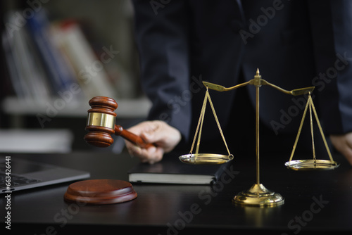 Hand holding a wooden gavel, a wooden legal gavel on an office desk, Judge gavel, Law,