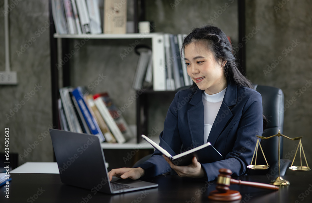 Φωτογραφία Lawyer woman holding a law book with a wooden legal gavel on an office desk, justice and law concept