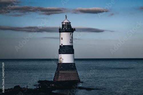 Idyllic Penmon lighthouse on a pier overlooking water in Anglesey, Wales