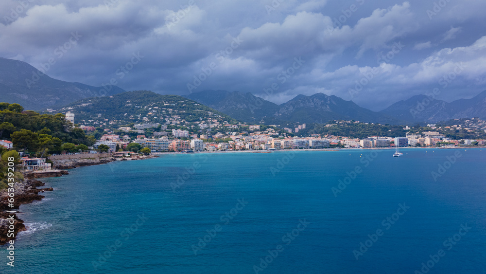 Aerial view of The French Riviera at Menton, France. Photography was shoot from a drone at a higher altitude from above the bay with the city and the mountains in the background on a stormy weather.