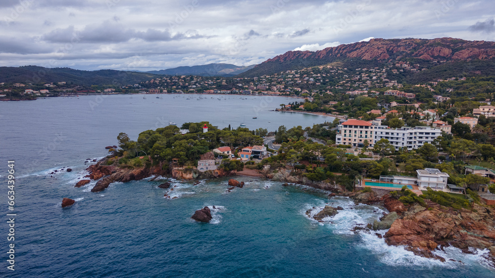 Fototapeta premium Aerial video of the Agay bay on the French Riviera. In the photography can be seen Agay lighthouse and a panorama of the bay, with mountains in the background. Photography was shot on a cloudy day.