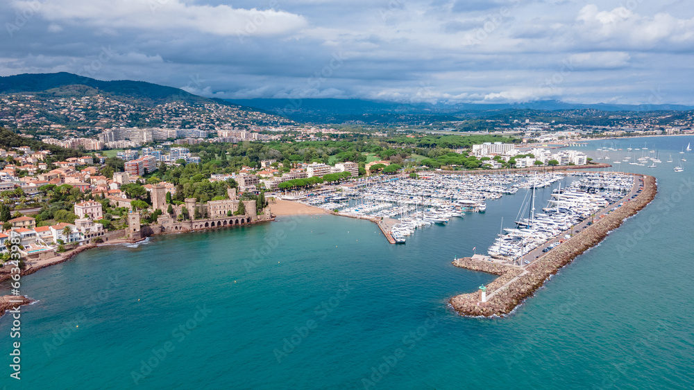 Aerial view of Château de la Napoule at the French Riviera. Photography was shot from a drone at a higher altitude from above the water wit the beautiful marina and beach in the view.

