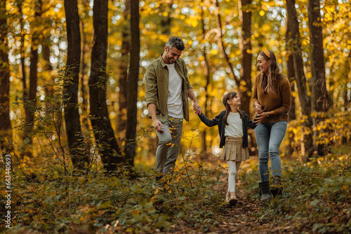 Bilde på lerret Mother, father and their daughter having a walk trough the forest